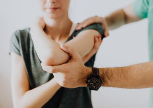 doctor helping patient with arm stretches